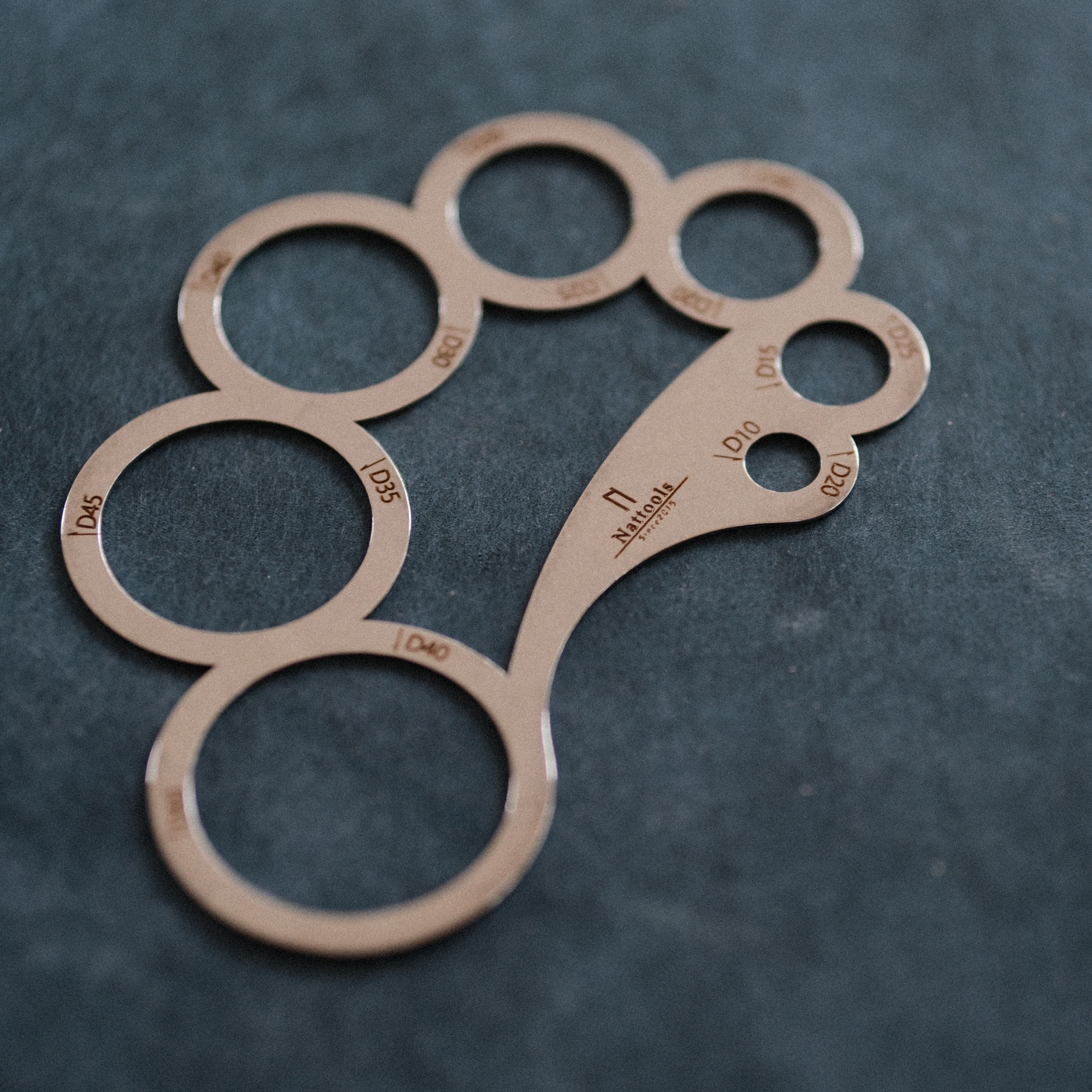 A compact leather circle marking template for drawing rounded corners, circle layouts, hole positioning, and smooth curves. Lightweight, flexible, and easy to handle, with polished edges and a stonewashed finish. Ideal for wallets, card holders, and pattern making. Shop now.