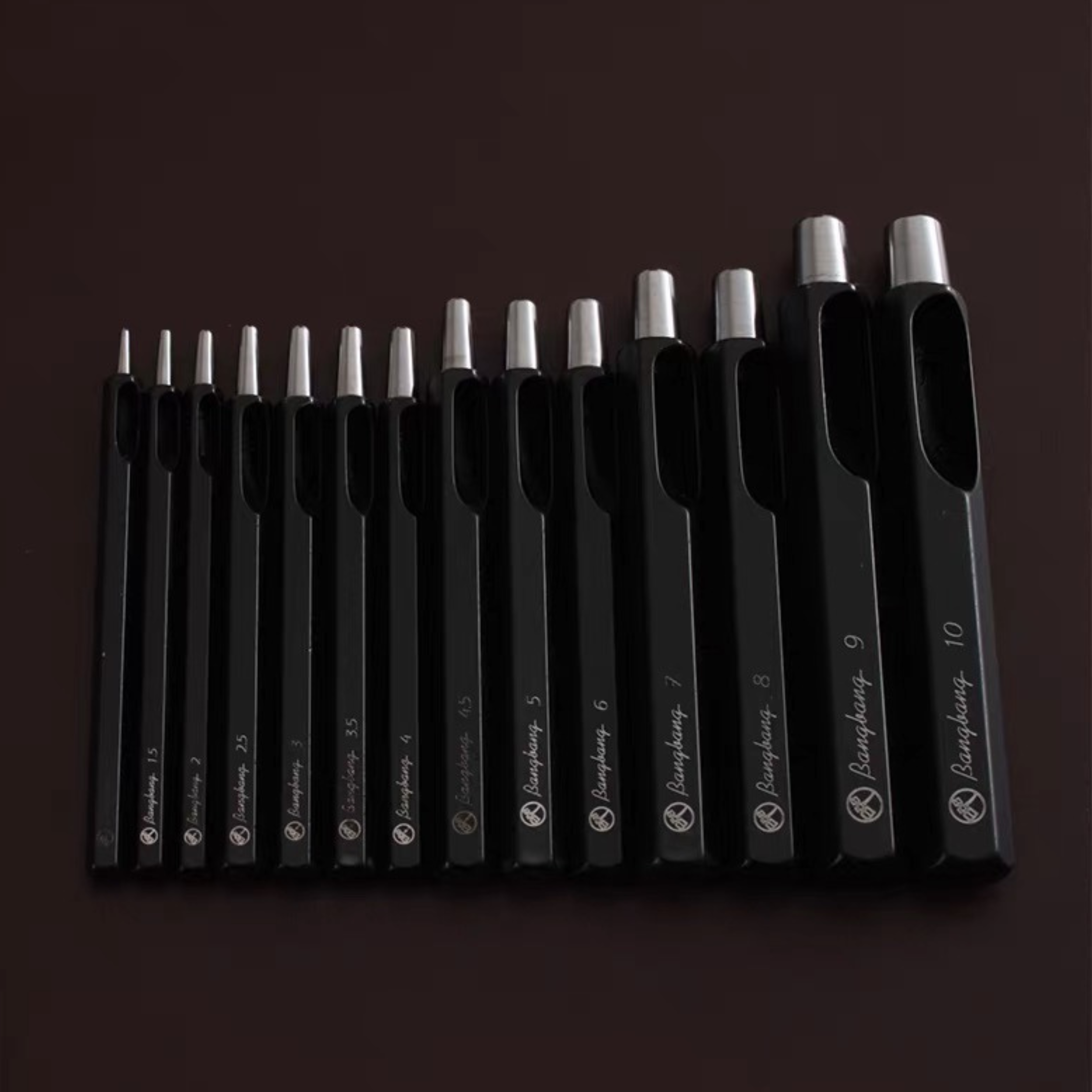 Taiwan-made Bangbang hex round punch set for leathercraft. High-toughness special alloy steel punches with black finish and wooden base, ideal for clean belt holes, hardware holes, and round leather punching.