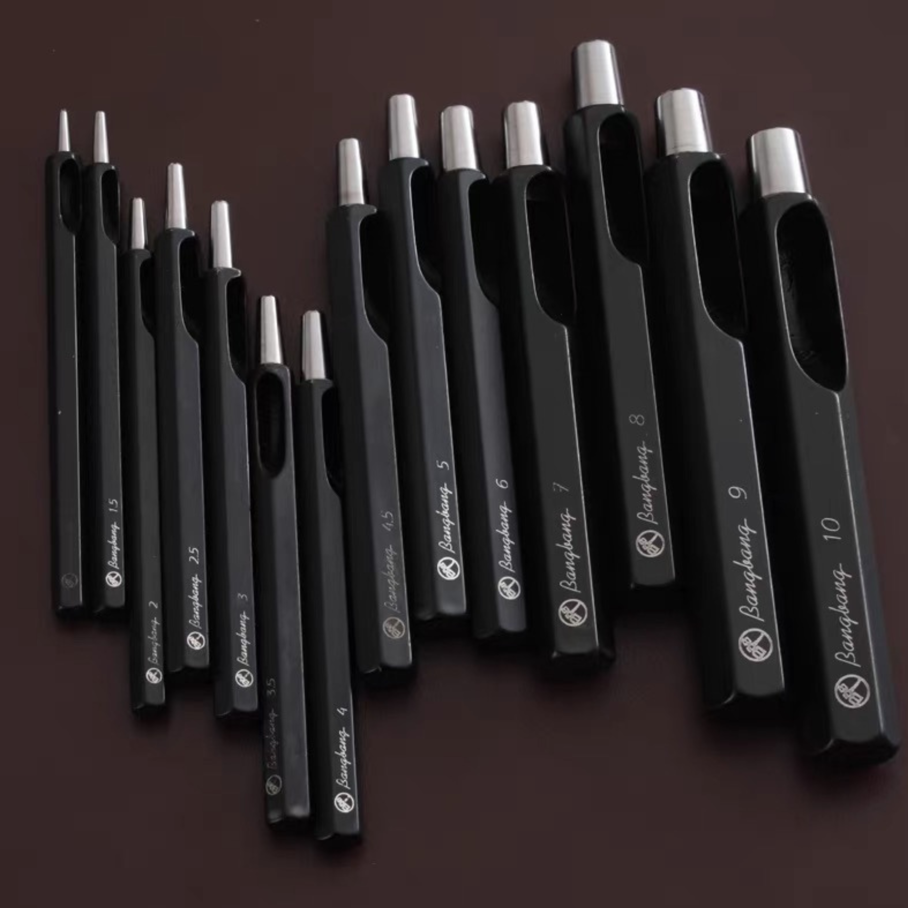 Taiwan-made Bangbang hex round punch set for leathercraft. High-toughness special alloy steel punches with black finish and wooden base, ideal for clean belt holes, hardware holes, and round leather punching.