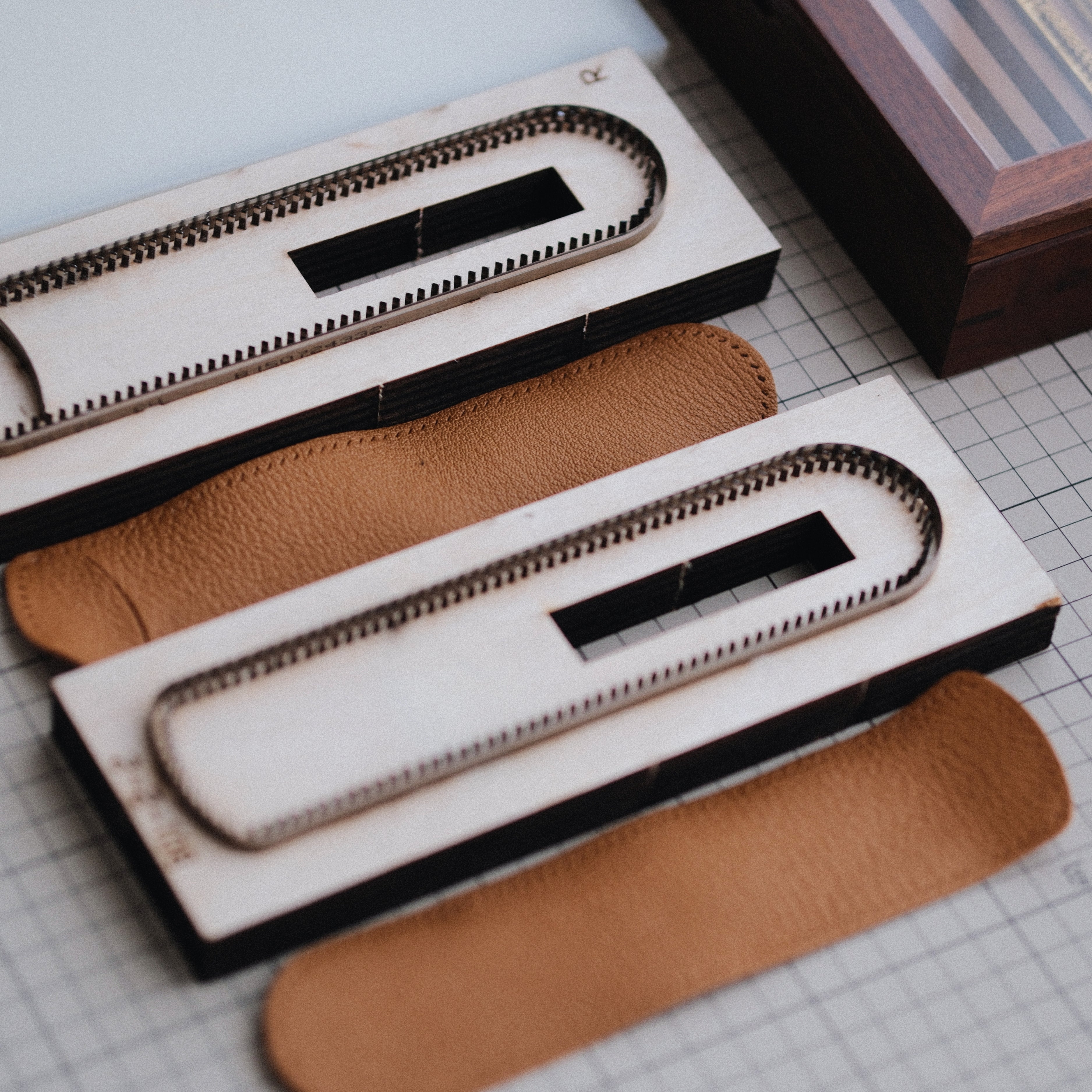 Custom leather pen sleeve cutting die with Japanese steel blade, wooden base, and built-in stitching holes. Made for clean cutting, accurate hole placement, and custom leather pen case production.