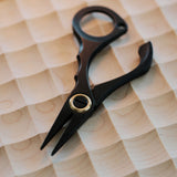 Stainless steel needle pulling pliers for leather hand stitching. Compact one-hand design with finger ring, spring-back jaw, and serrated flat tips to grip stuck needles through thick leather or tight stitch holes. Shop now.