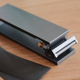 Aluminum sandpaper sharpening base for leathercraft knives and edge tools. CNC-machined with an anodized finish, non-slip silicone backing, and a flat clamping design for easier, more consistent sharpening. Includes 600, 1200, and 2000 grit sandpaper. Shop now.