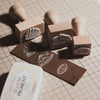 Custom wooden rubber stamp for leather, paper, cardboard, fabric, packaging, tags, and notebook covers. Made from your logo, text, or artwork, with a free Japanese ink pad included. Clean, handmade stamping for branding and packing. Send your design to get started.