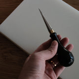 Leathercraft scratch awl for marking lines, opening holes, and widening stitch holes. Made with a solid 304 stainless steel tip and rosewood handle for balanced everyday use in hand stitching and leatherworking. A useful bench tool for daily leathercraft work. Shop now.
