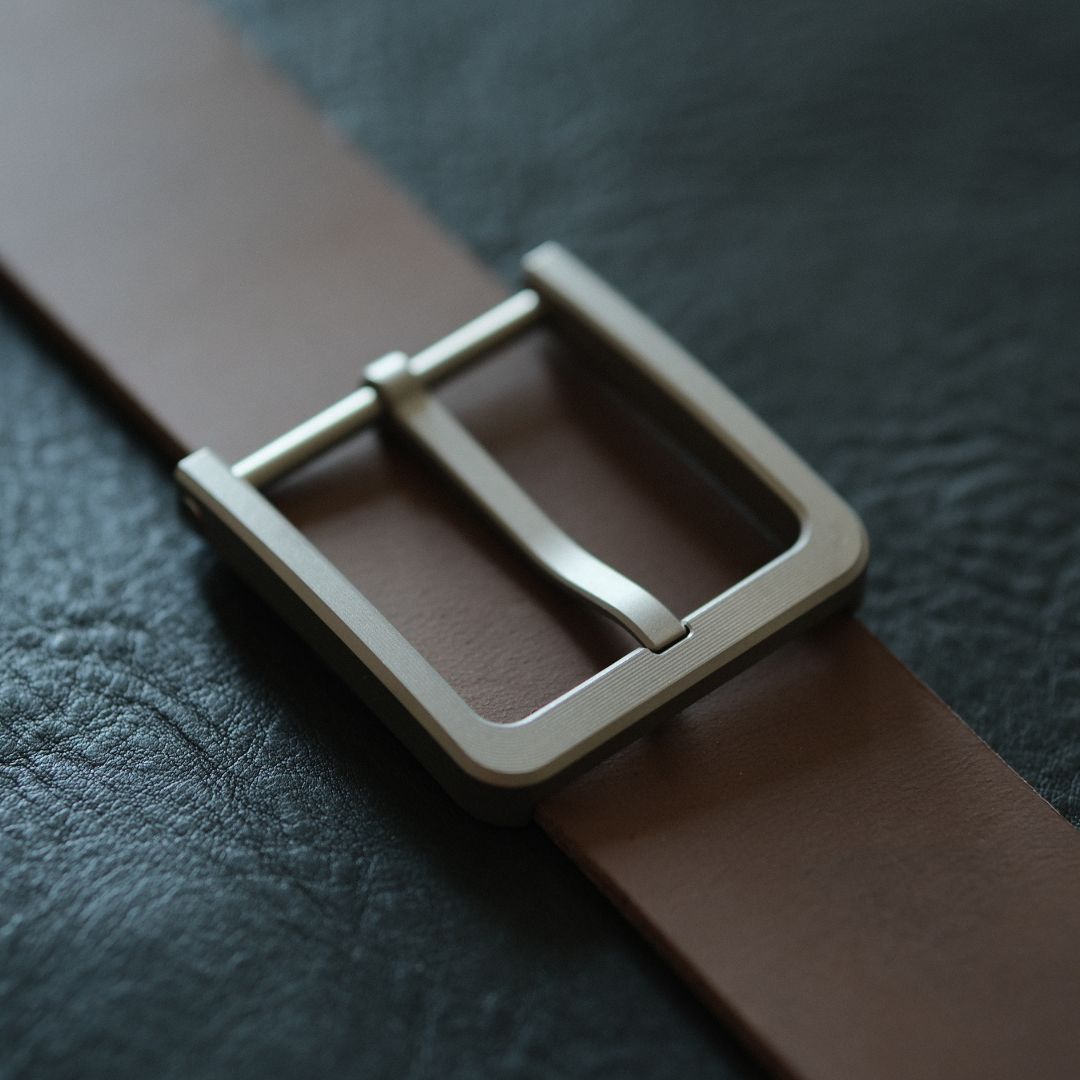 The overall design is simple yet rich in detail. The sleek side curves and smooth inner corners add to its minimalist elegance, giving it a refined, understated look. The buckle comes in a gray color that subtly shifts under different lighting conditions, creating a unique visual effect. We’ve provided photos with various backgrounds for you to see how it looks in different settings.