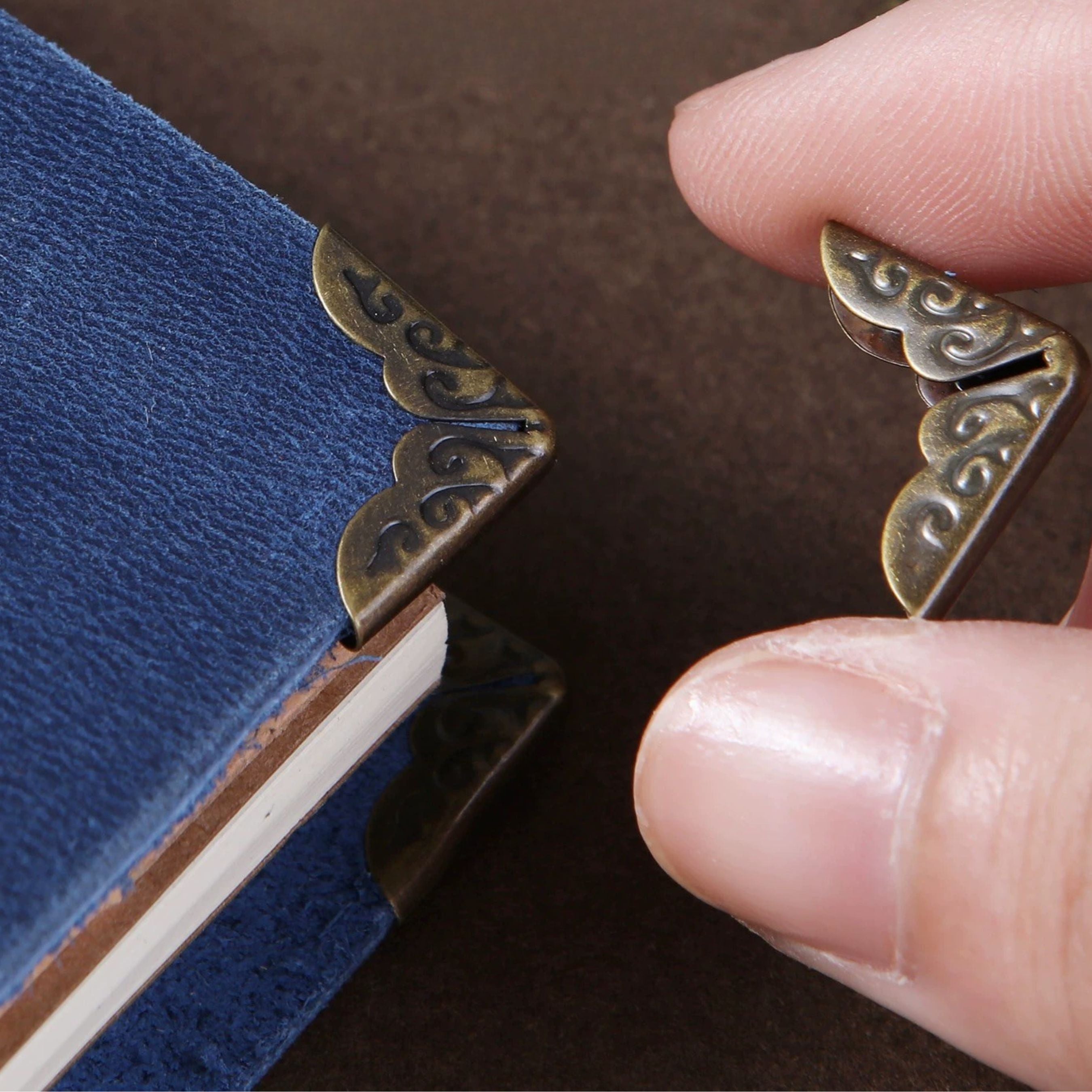 Vintage style book corner protectors in antique-finish stainless steel for journals, notebooks, scrapbooks, and bookbinding projects. Helps protect corners from wear while adding a classic decorative touch to handmade books and covers. Shop the set here.