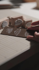 Custom wooden rubber stamp for leather, paper, cardboard, fabric, packaging, tags, and notebook covers. Made from your logo, text, or artwork, with a free Japanese ink pad included. Clean, handmade stamping for branding and packing. Send your design to get started.